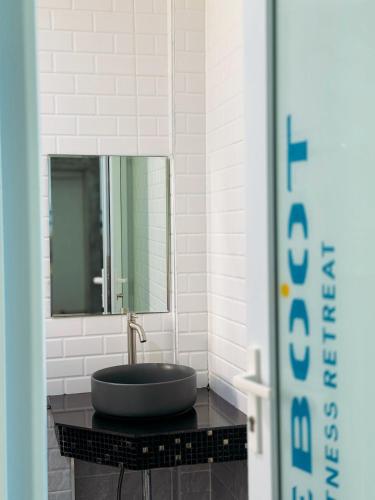 a bathroom with a black sink and a mirror at Reboot Retreat Beach Resort, Restaurant, and Coffee Shop in Ban Talat Bang San