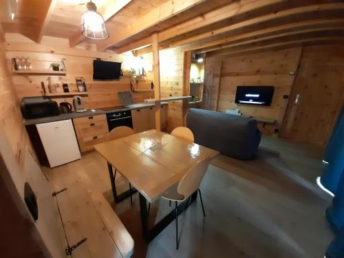 a kitchen and living room with a table and chairs at Le verger de Togne chalet 1 in Villafans