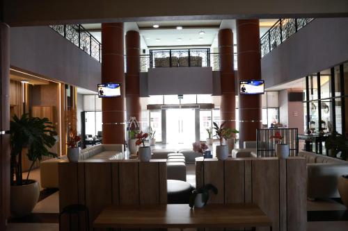 a lobby with a waiting area with tables and windows at De Balen Soultan Hotel in Puyung