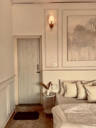 a bedroom with a bed and a table with a lamp at Nazaara - Mukteshwar - Mountain view and sunset from your bed in Mukteswar