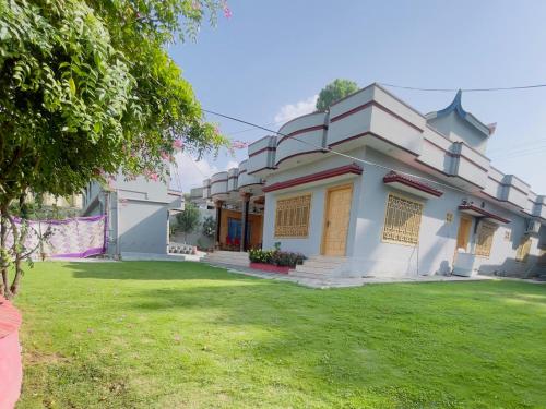 a house with a lawn in front of it at Roomy star resorts in Abbottābād