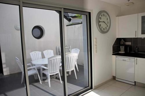 a kitchen with a table and chairs and a clock at Maison "TY CASTERO" in Quiberon