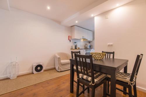 Central Lisbon Stay with Terrace في لشبونة: مطبخ وغرفة طعام مع طاولة وكراسي