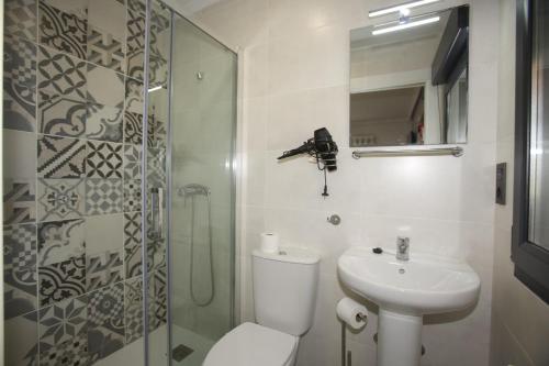 a bathroom with a toilet and a sink and a shower at Apartamentos La Cueva - Onis in Avín