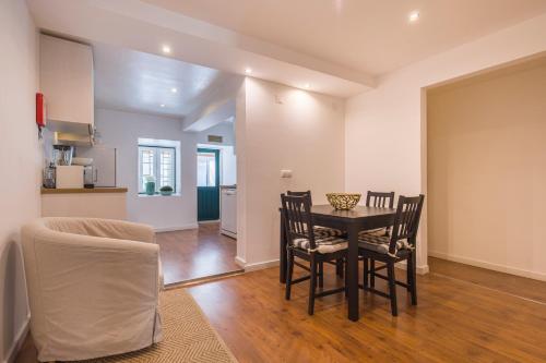 Central Lisbon Stay with Terrace في لشبونة: غرفة طعام ومطبخ مع طاولة وكراسي