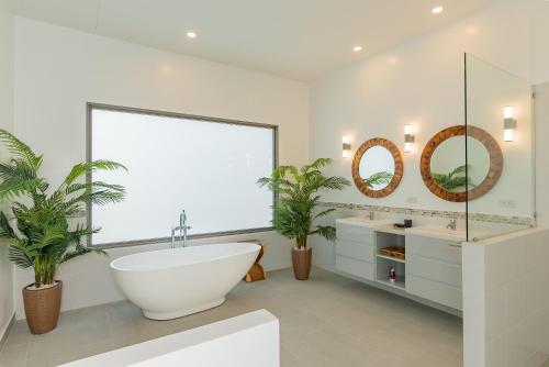a bathroom with a large window and a tub and two sinks at villa Akala in Ban Saiyuan (1)