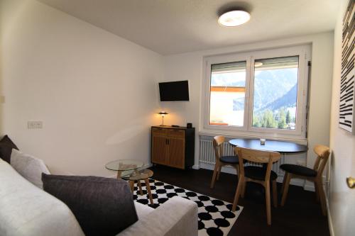 a living room with a couch and a table and a window at Jäggi 35 by Arosa Holiday in Arosa