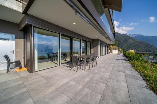a patio with chairs and a table on a building at Modern 5-Star Stay in Glion - Underfloor Heating in Montreux