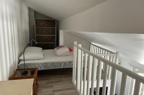 a small room with a bed and a staircase at Duplex Mezzanine au calme Place de l'Horloge in Avignon