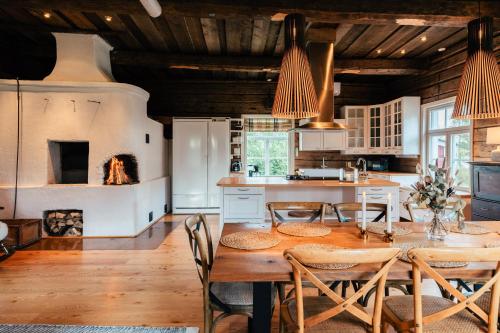 a kitchen with a table and chairs and a kitchen with white cabinets at Lapland Heritage Villa in Ranua