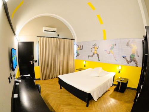 a bedroom with a white bed and a yellow wall at ibis Styles Rio Preto Monte Libano in Sao Jose do Rio Preto