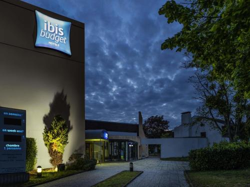 a building with a sign on the side of it at ibis budget Saint-Ouen-l'Aumône in Saint-Ouen-lʼAumône