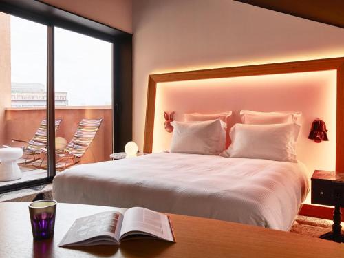 a bedroom with a bed and a table with a book at Mama Shelter Toulouse in Toulouse