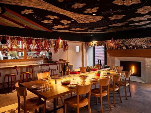 a dining room with a table and a fireplace at Mama Shelter Toulouse in Toulouse