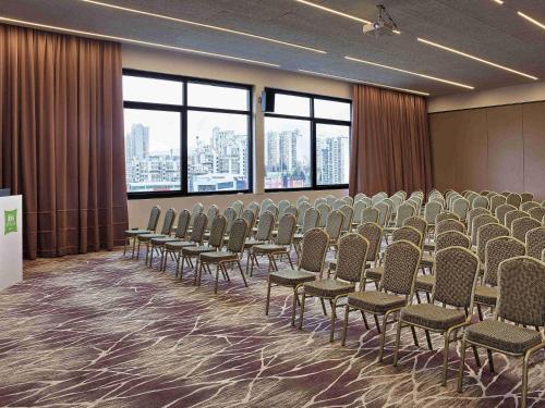 a conference room with rows of chairs and windows at ibis Styles Sarajevo in Sarajevo