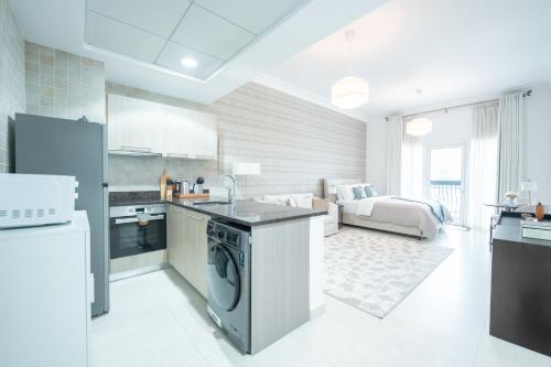 a kitchen and living room with a sink and a dishwasher at Modern Studio Living by Voyage in Abu Dhabi