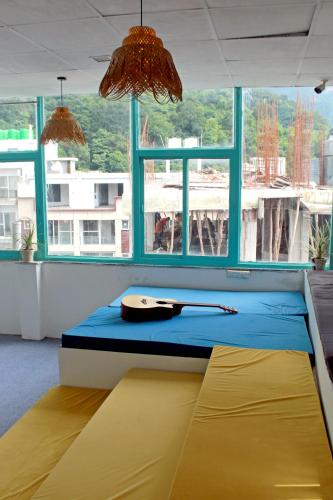 a room with a bed in a room with windows at Hostel De Offlanders Rishikesh - Stay Connect & Explore in Tapovan