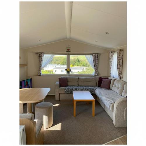 a living room with a couch and a table at Caravan - sleeps 6 & parking in Hollington
