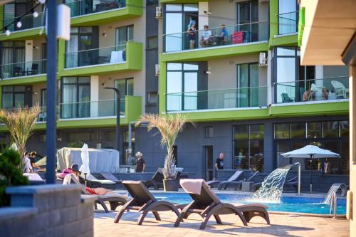 a hotel with a swimming pool and chairs and a building at Apartament Horizon by Alz in Mamaia Sat/Năvodari