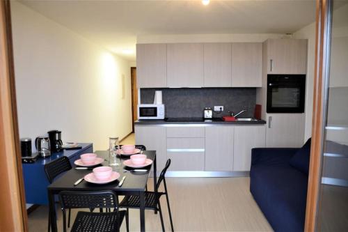 a kitchen and a dining room with a table and chairs at Le Panoramic Evian in Évian-les-Bains