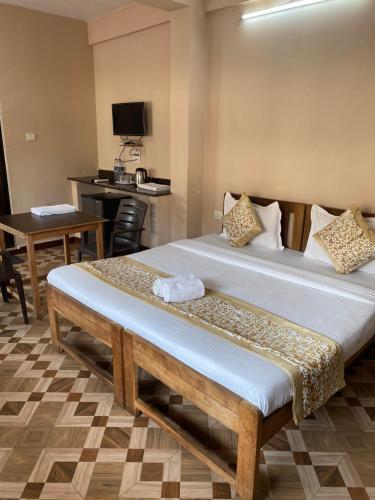 a hotel room with two beds and a table at Hotel The Baga Prime in Baga