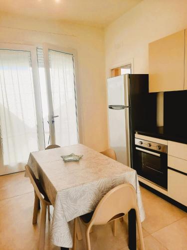 a small kitchen with a table and a refrigerator at Azzurro Mare Aparthotel in Torre Mozza