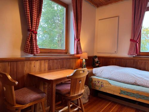 une chambre avec une table, un lit et une fenêtre dans l'établissement Berghaus auf 1200m Höhe, à Bodental