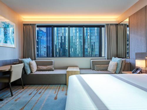 a hotel room with a bed and a large window at Novotel Melbourne Central in Melbourne