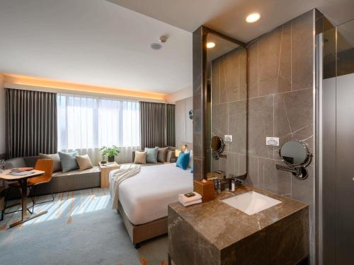 a hotel room with a bed and a bathroom at Novotel Melbourne Central in Melbourne