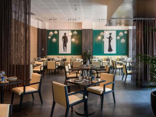 a dining room filled with tables and chairs at Novotel Melbourne Central in Melbourne