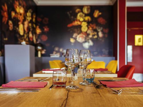 a wooden table with wine glasses on top of it at ibis Styles Douai Gare Gayant Expo in Douai