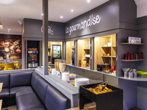 a fast food restaurant with a counter with food at ibis Styles Douai Gare Gayant Expo in Douai