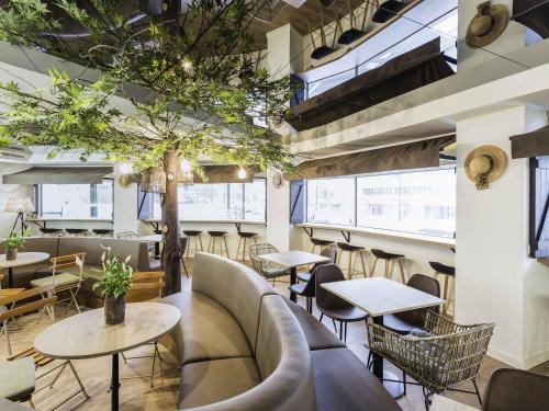 a restaurant with tables and chairs and a tree at Ibis Styles Lisboa Centro Marquês de Pombal in Lisbon