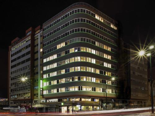 a large office building at night with lights on at Ibis Styles Lisboa Centro Marquês de Pombal in Lisbon