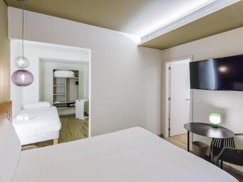 a room with a white bed and a table and a chair at Ibis Styles Lisboa Centro Marquês de Pombal in Lisbon