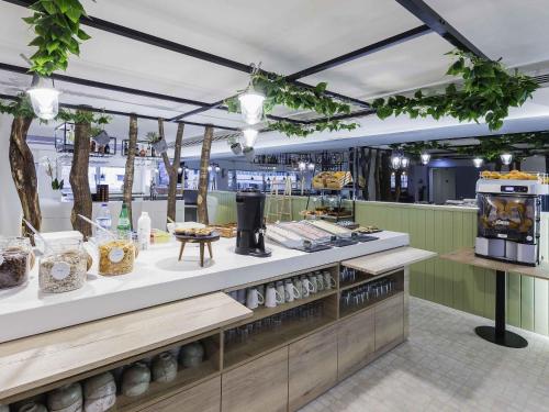 a restaurant with a counter with food on display at Ibis Styles Lisboa Centro Marquês de Pombal in Lisbon