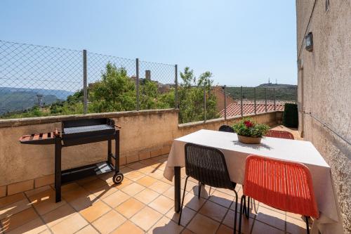 a table and chairs on a balcony with a piano at Eremita in La Figuera