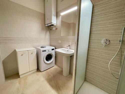 a bathroom with a washing machine and a sink at Apartment with garden and pool in Caorle