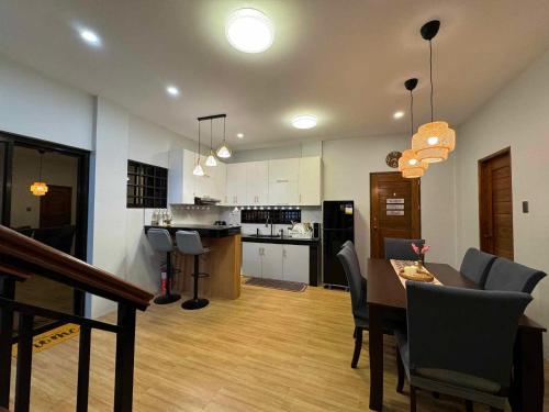 una cucina e una sala da pranzo con tavolo e sedie di Casa Corazon - Pineview Heights - Amadeo Tagaytay a Dagatan