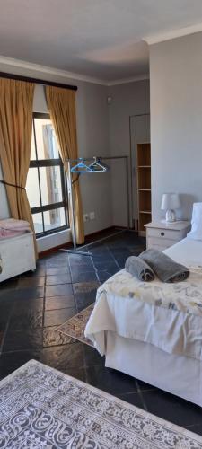 a bedroom with two beds and a room with a window at 22 on Shiraz 2 in Bellville