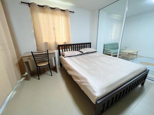 a bedroom with a bed and a table and chairs at ชาโตว เรสซิเดนซ์ Chateau Residences in Ban Khlong Nung