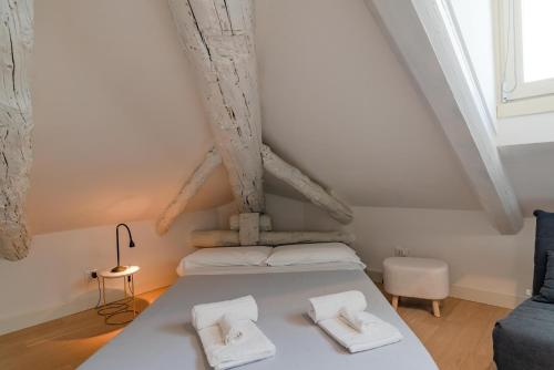 una camera da letto con un letto con due asciugamani bianchi di Suites Mozart & Chopin by Toh Solution a Torino