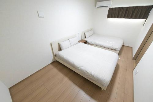 a small room with two beds in a room at LA-CHIC Stay 大津 in Ozu
