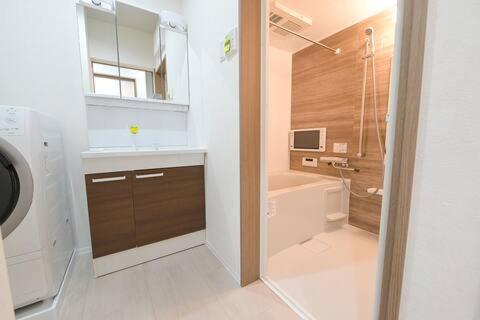 a bathroom with a tub and a sink and a shower at LA-CHIC Stay 大津 in Ozu