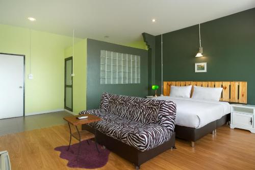 a bedroom with a bed and a couch at Yak Guesthouse in Chiang Mai
