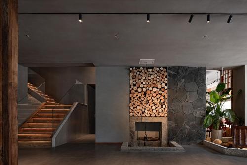 a room with a fireplace with a pile of logs at Zhangjiajie SANHE Hotel --Free one way pick up service over 2 night, Free shuttle to east gate of forest park,Free laundry service,Free fresh coffee,English speaking customer service in Zhangjiajie
