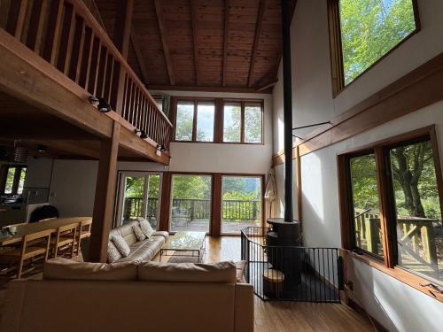 a living room with a couch and a table at Cabin A MtFuji view, BBQ, lake Saiko 3mins, hammock, wood deck in Narusawa