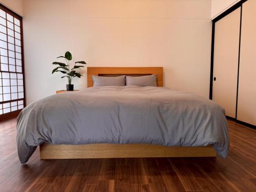 a bedroom with a bed and a potted plant at ZEN stay Nikko in Nikko