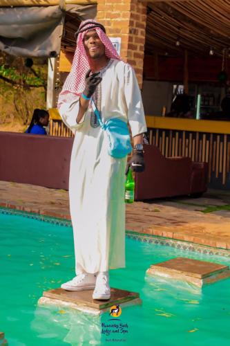a statue of a man standing on a board in the water at Pamensky Bush Lodge and Spa in Hartbeespoort