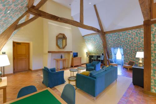 a living room with a blue couch and chairs at Hôtel Golf Château de Chailly in Chailly-sur-Armançon